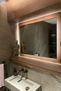 Stylish bathroom interior featuring a modern sink, illuminated mirror, and decorative statue, showcasing Solved Construction's renovation expertise.