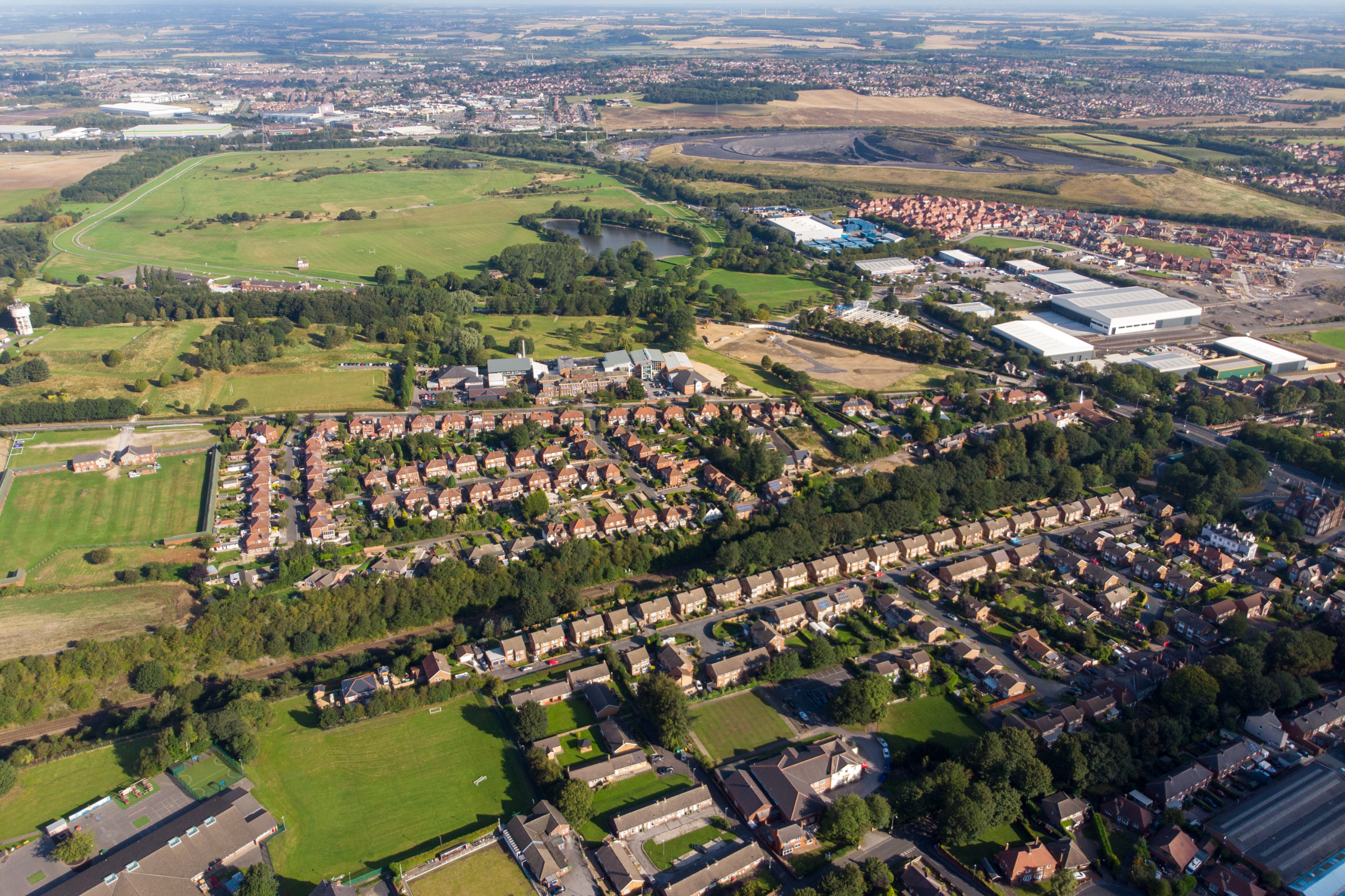 Aerial view of Pontefract showcasing residential neighborhoods, green spaces, and commercial areas, relevant to Solved Construction's services in local building and renovation projects.