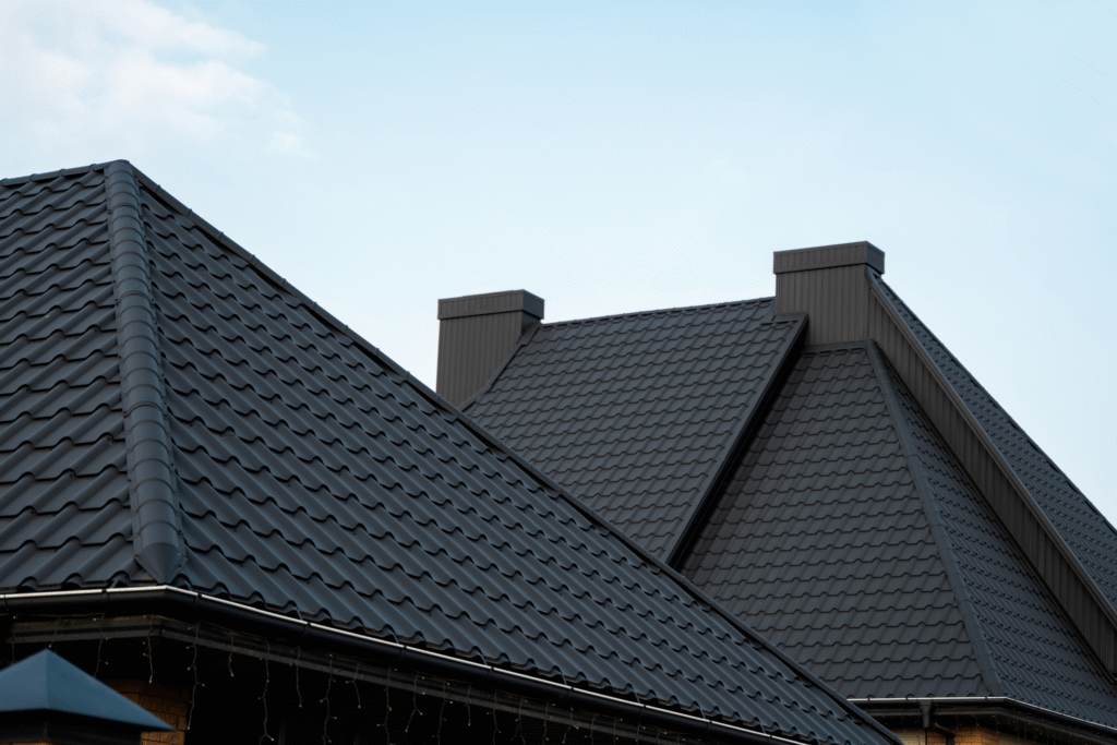 Roofing with dark, textured tiles on pitched roofs, showcasing durability and weatherproofing for construction projects.